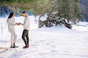 un homme et une femme debout dans la neige