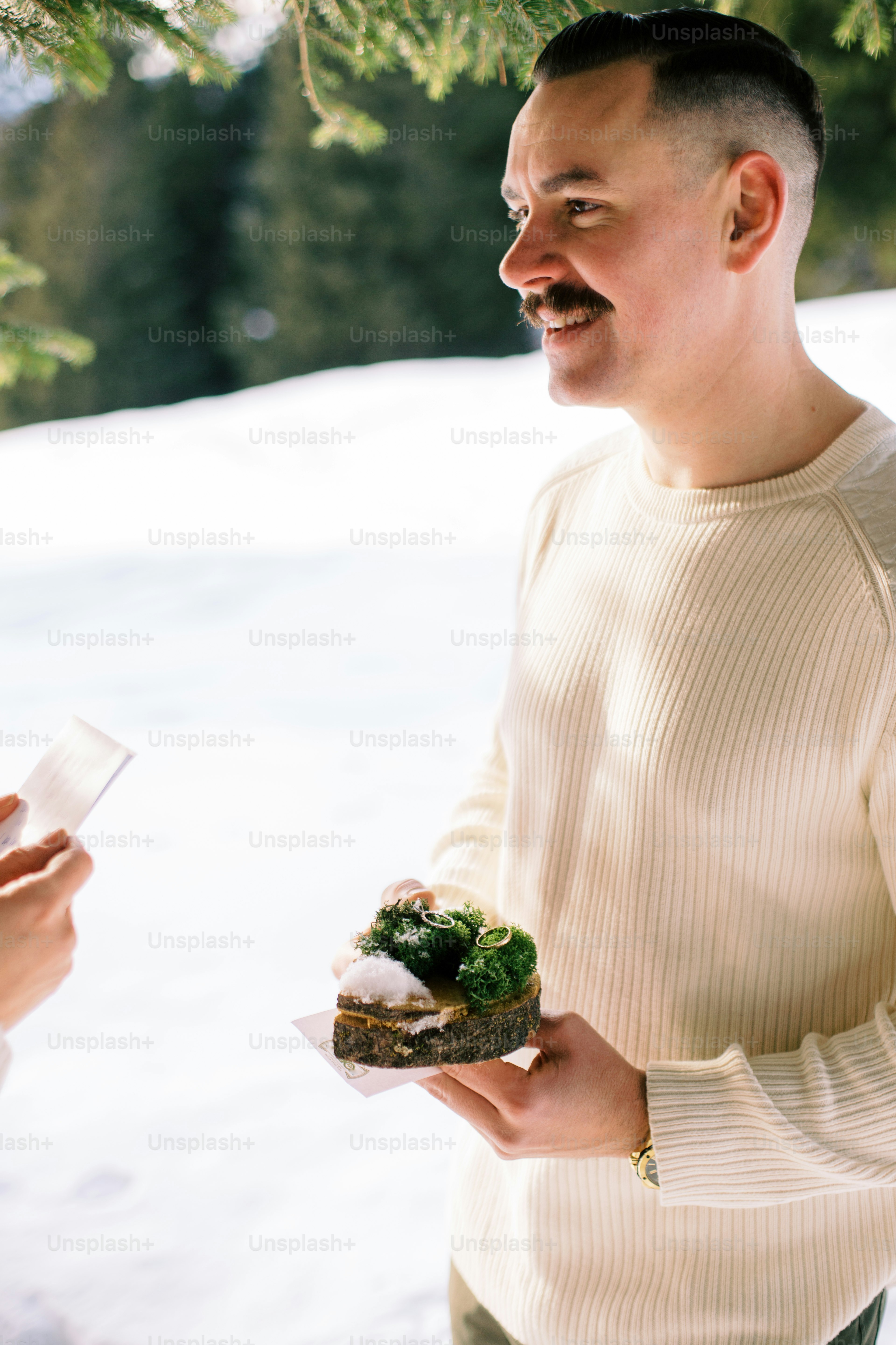 a man holding a sandwich in the snow