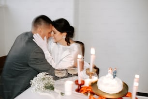 a man and woman sitting at a table with a cake