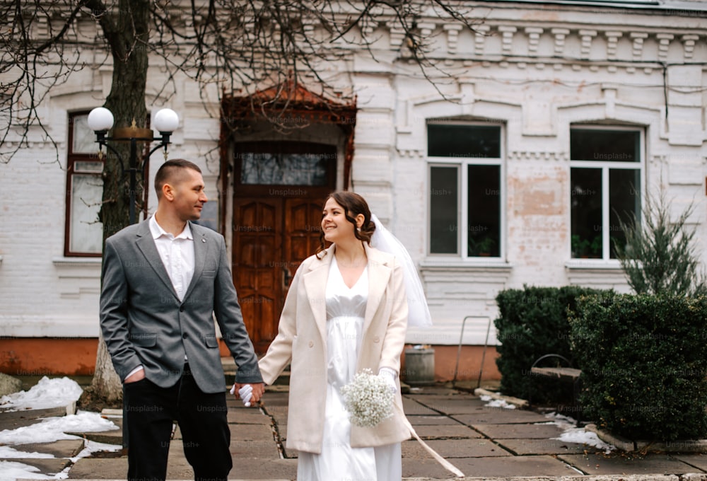 a bride and groom are walking down the street