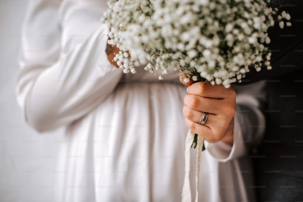 a bride holding a bouquet of baby's breath