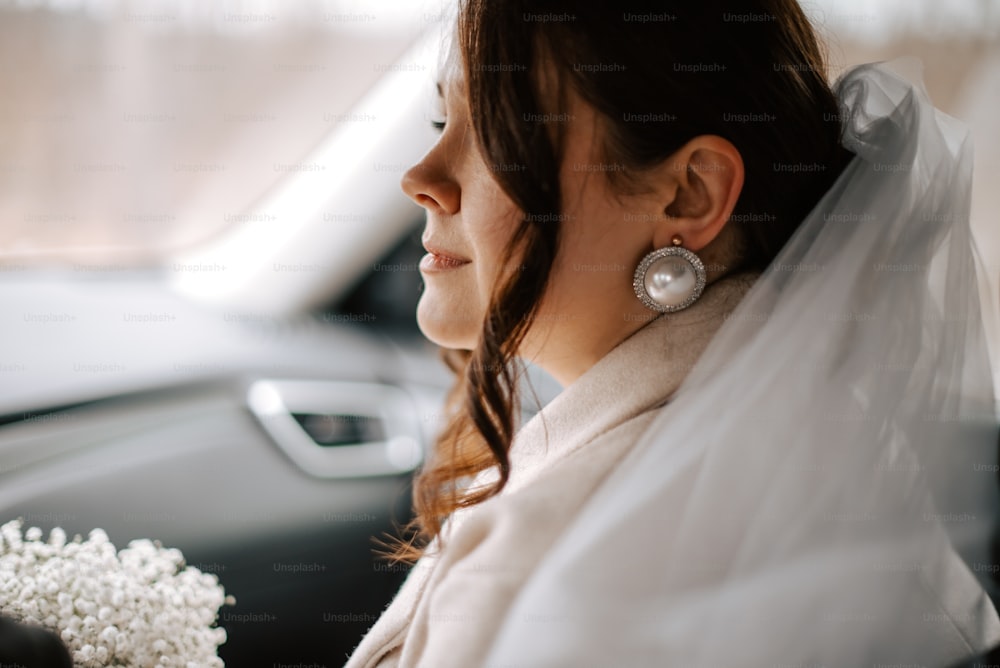 a woman sitting in a car with a bouquet of flowers