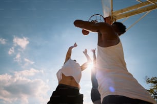 two people reaching for a basketball in the air
