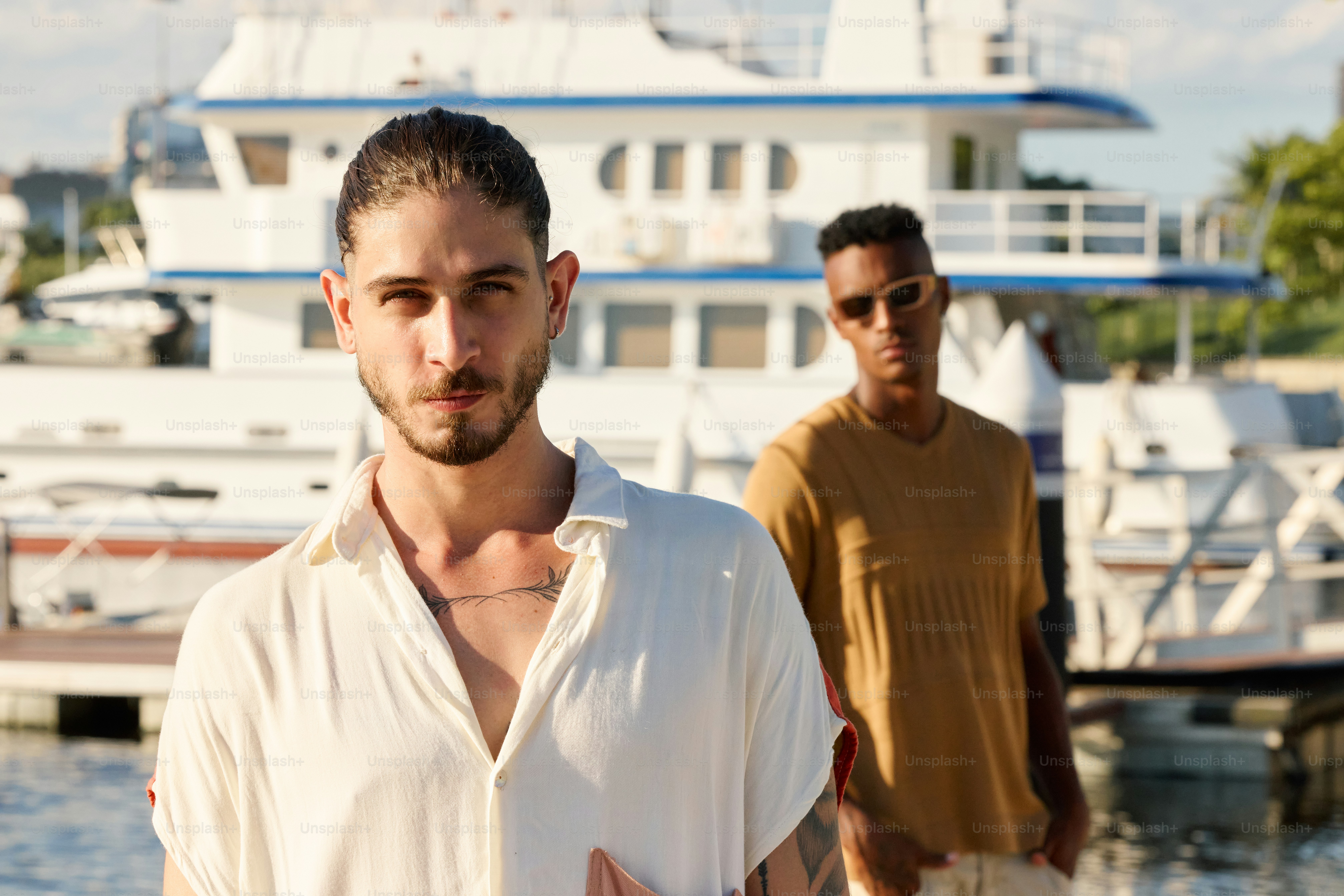 two men standing next to each other in front of a boat