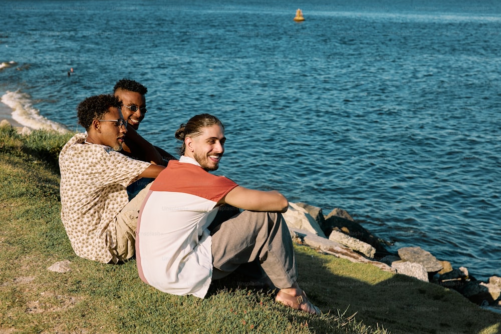um casal de pessoas sentadas ao lado de um lago