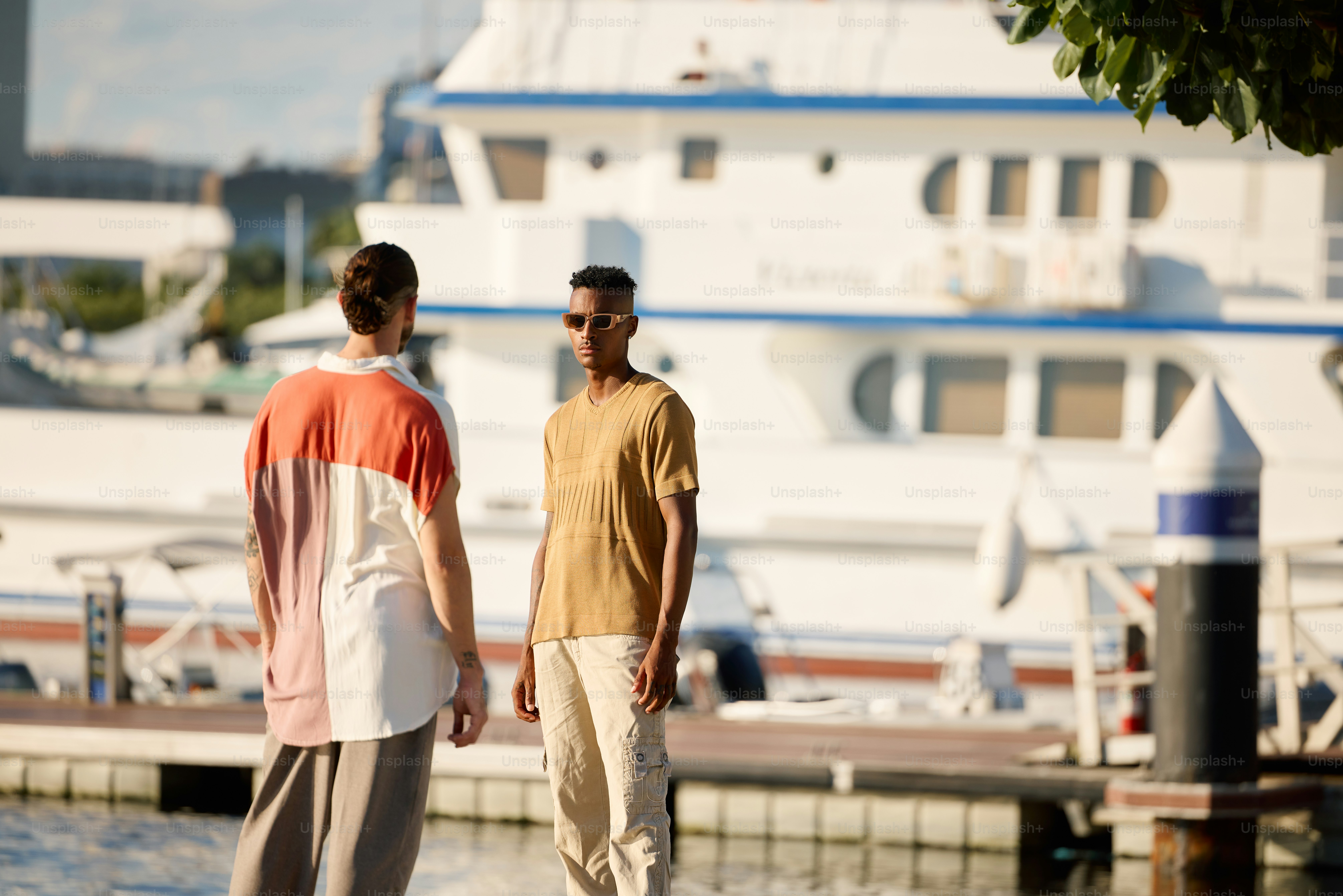 a couple of men standing next to each other near a body of water