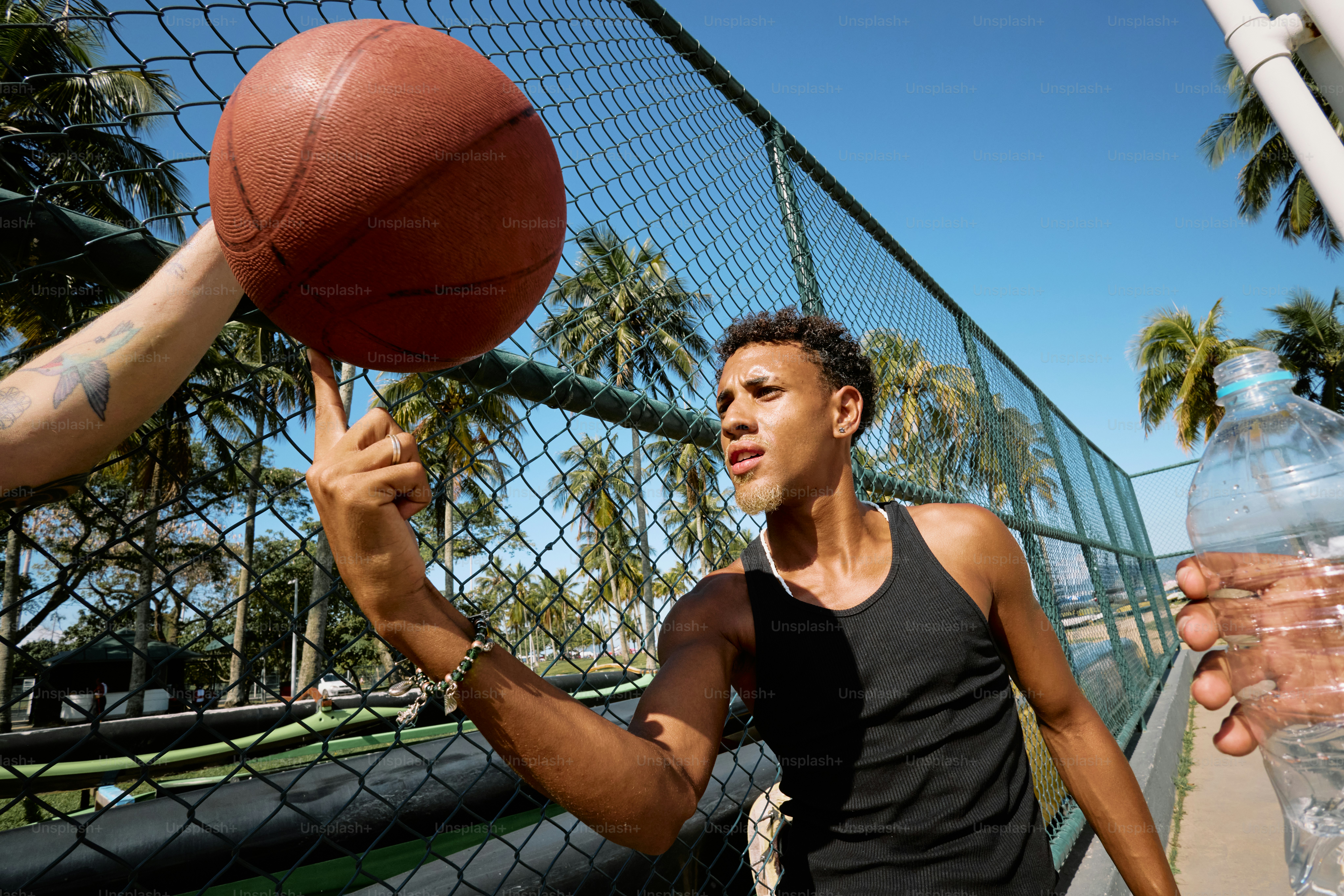 a man holding a water bottle and a basketball