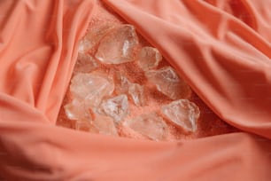 Eine Nahaufnahme von einigen Eiskristallen auf einem rosa Tuch