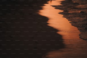 a person walking along a beach at sunset