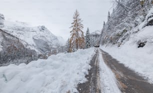 a snow covered road in the middle of a mountain
