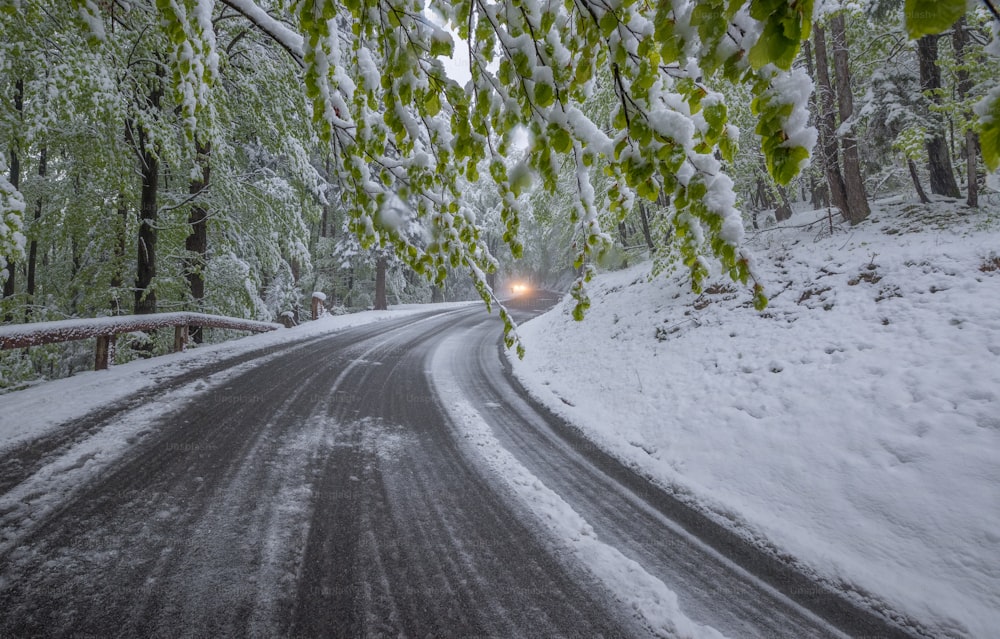 ein Auto, das eine schneebedeckte Straße entlangfährt