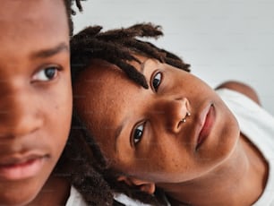 a couple of kids with dreadlocks standing next to each other