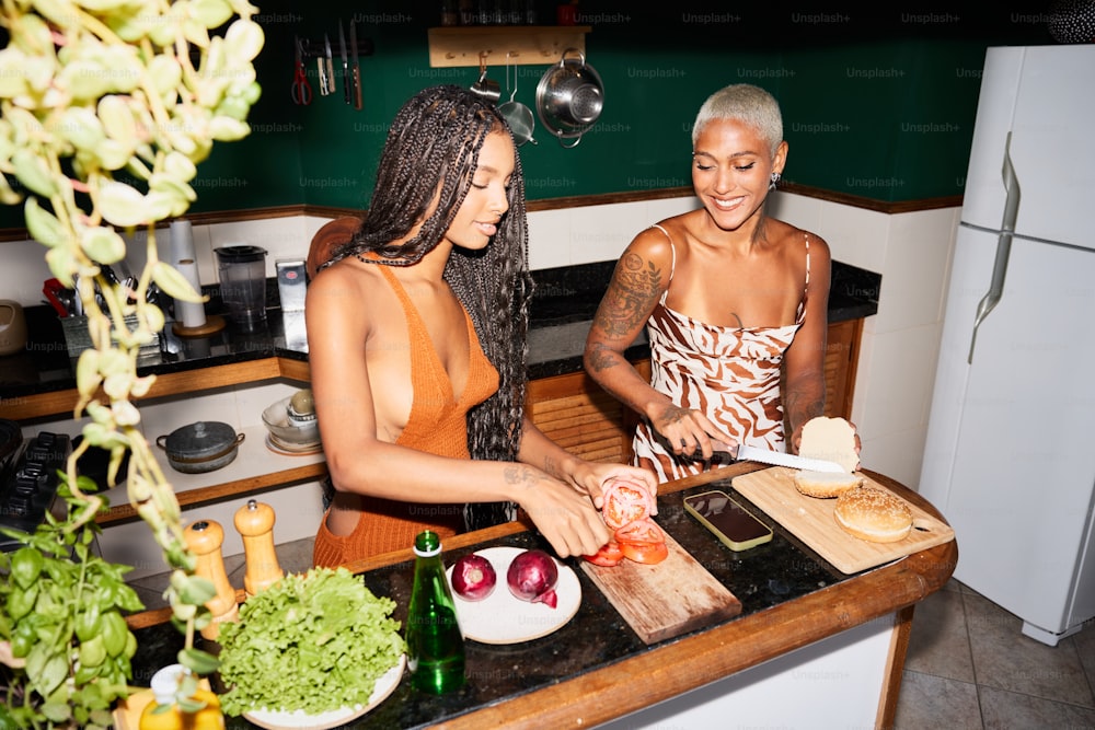 two women in a kitchen preparing food on a cutting board