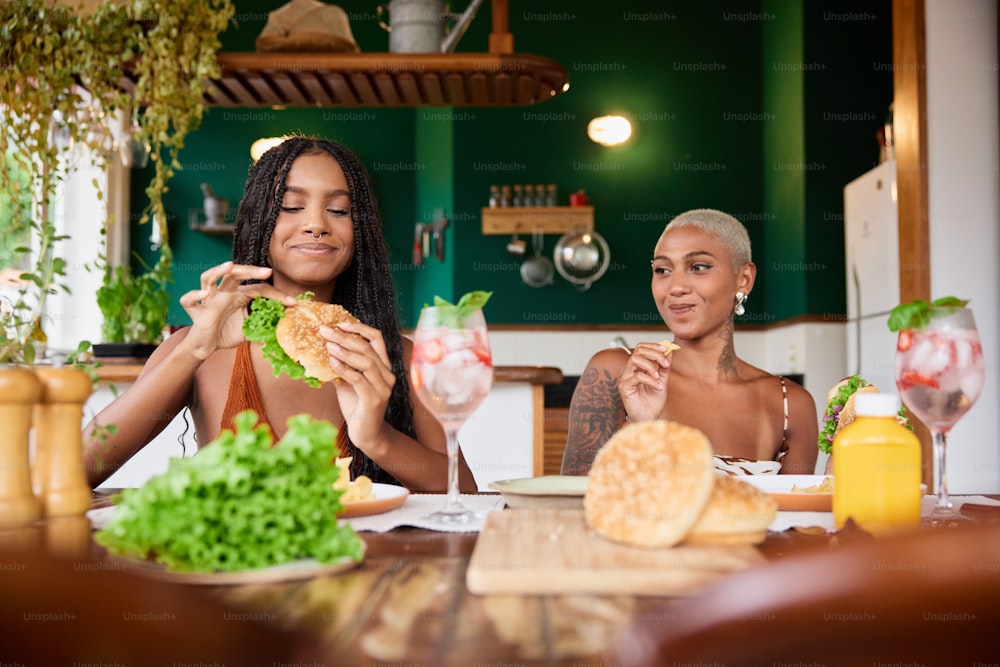 a couple of women sitting at a table with food
