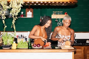 duas mulheres em pé em uma cozinha preparando comida
