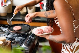a woman holding a plate of food in front of a stove