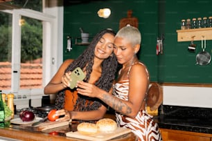 a couple of women standing next to each other in a kitchen