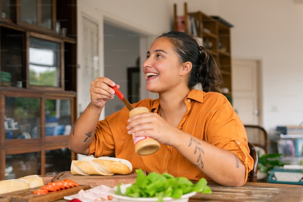 a woman sitting at a table eating a sandwich