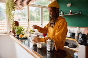 a man with dreadlocks is making a drink