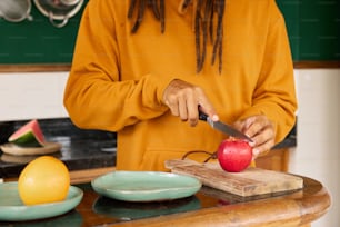 a person cutting an apple on a cutting board