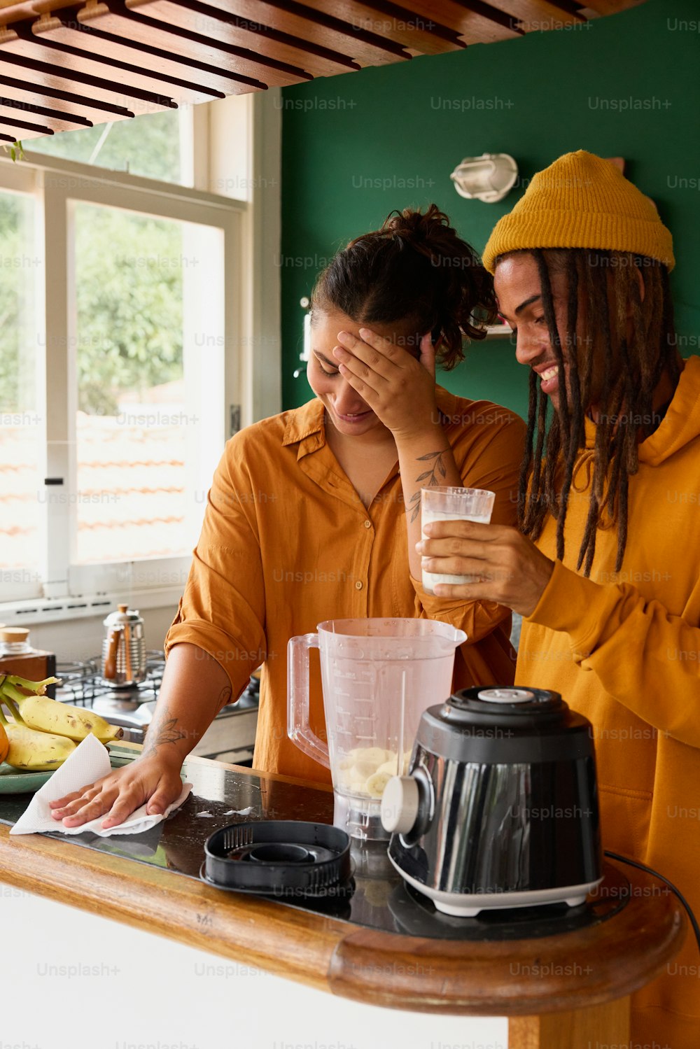 a couple of people standing next to a blender