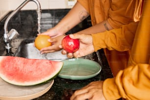 a person is peeling an apple and watermelon