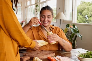una mujer sosteniendo un cuchillo y un frasco de comida