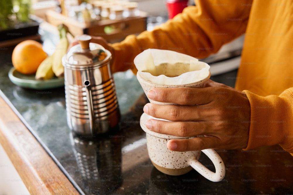 una persona sosteniendo una taza de café en un mostrador