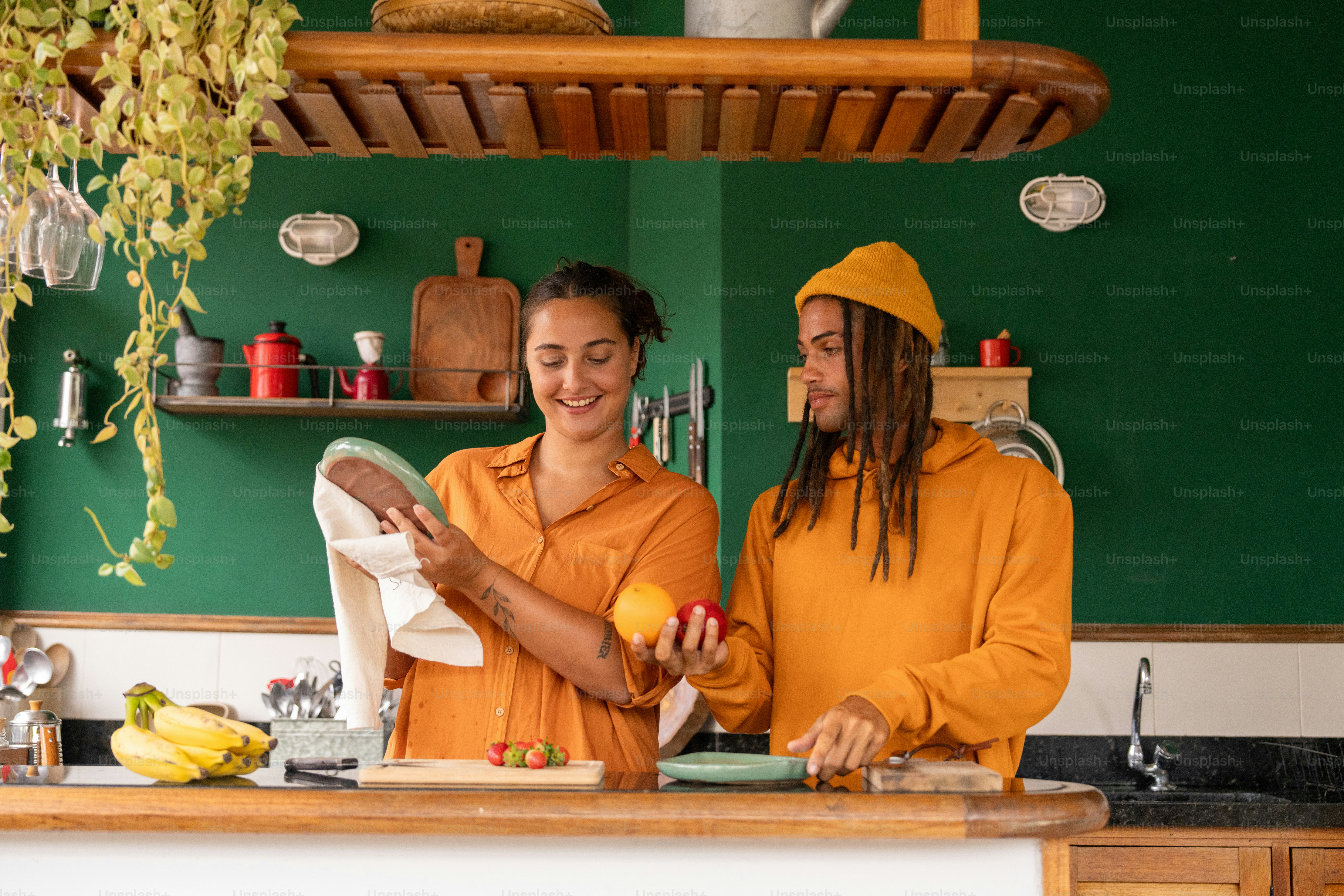 a couple of people standing in a kitchen