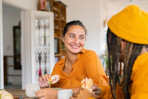 a couple of women sitting at a table eating food