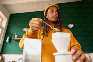 a man with dreadlocks eating a cup of coffee