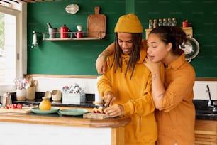 a man and woman standing in a kitchen preparing food