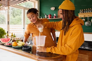 a woman pouring a drink into a blender