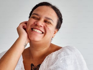 une femme souriante avec un tatouage de papillon sur son cou