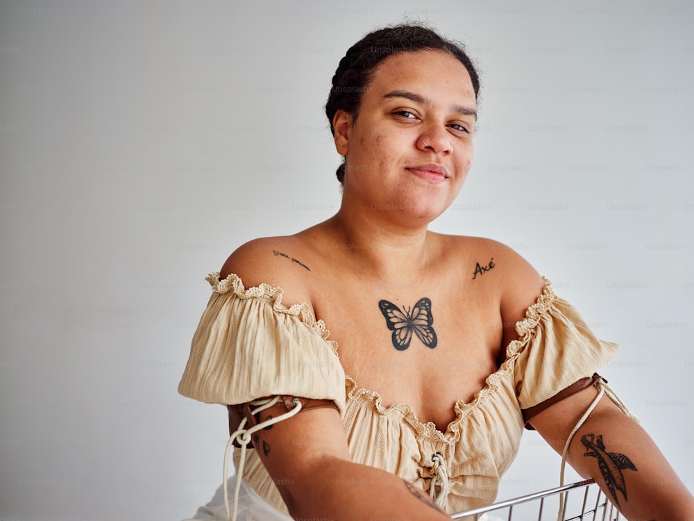 Eine Frau mit einem Schmetterlings-Tattoo sitzt in einem Korb