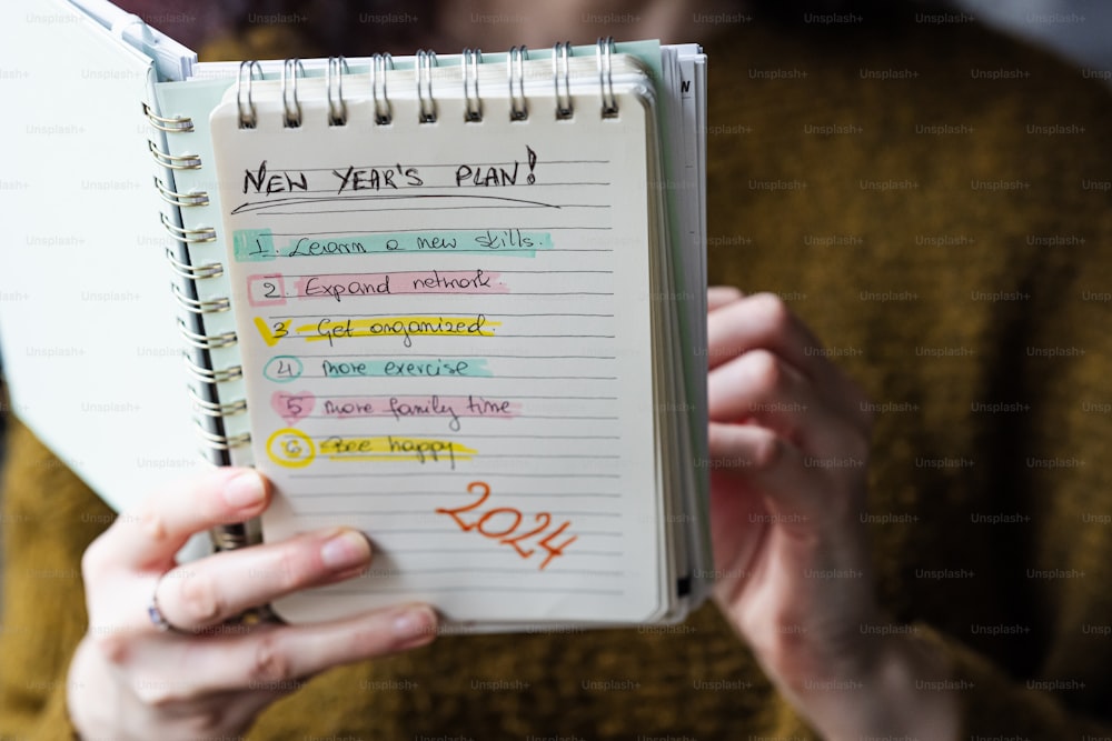 a woman holding a notebook with a list on it