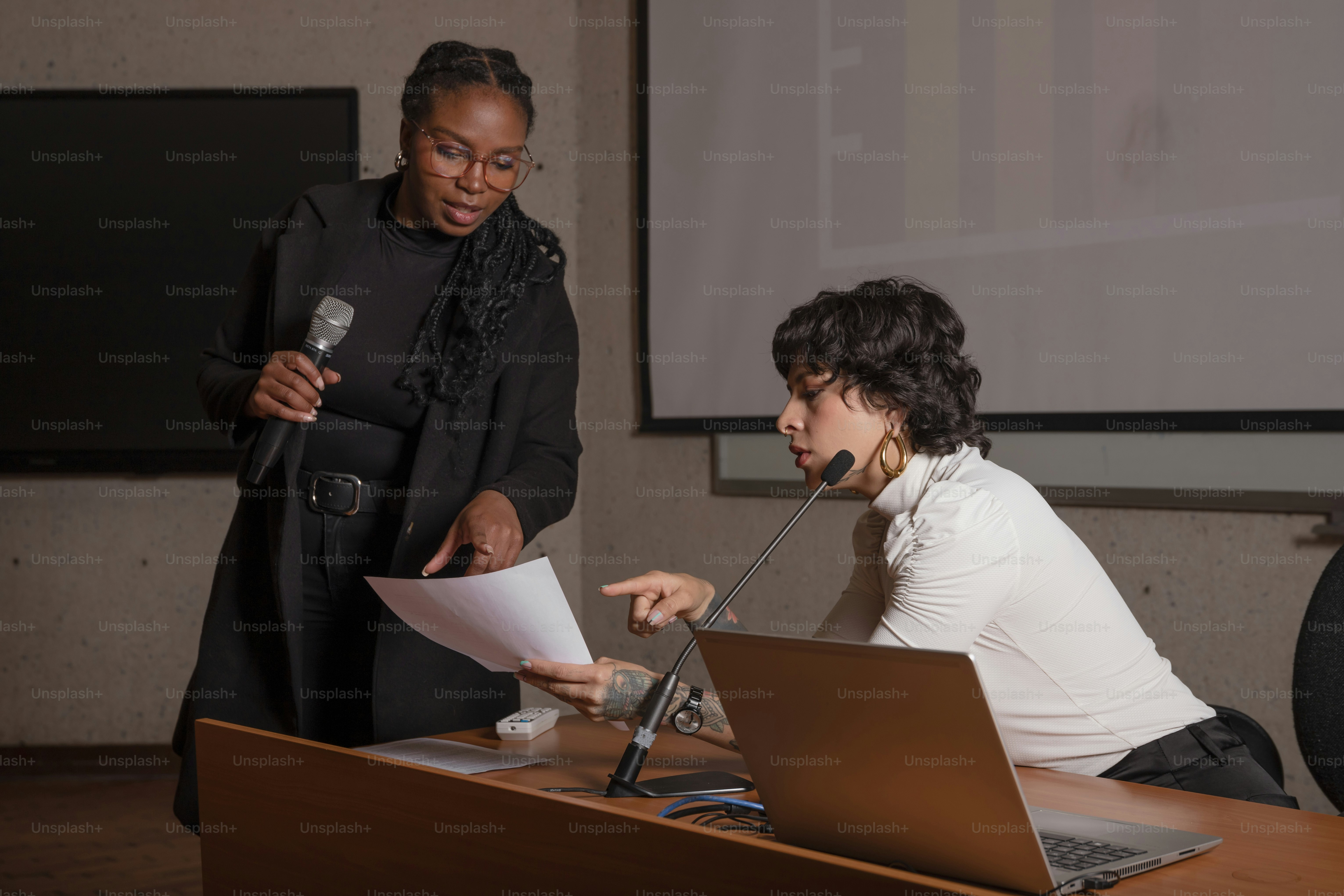 A woman standing in front of a laptop computer photo – Microphone Image ...