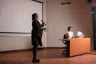 uma mulher em pé em um pódio fazendo uma apresentação