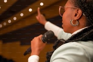 a woman in glasses is holding a microphone