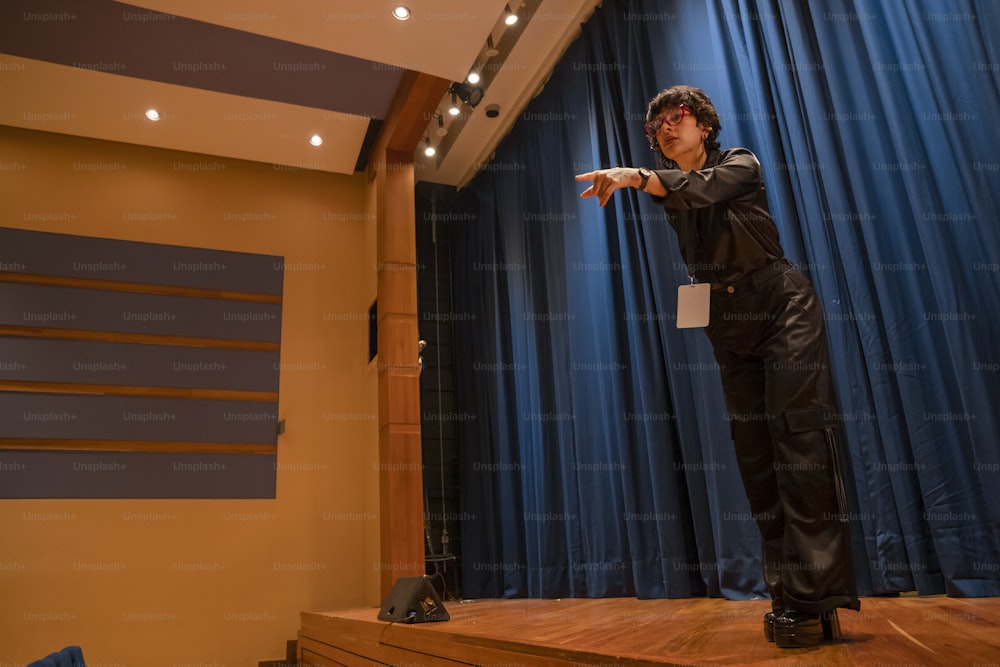 a man standing on a stage pointing at something