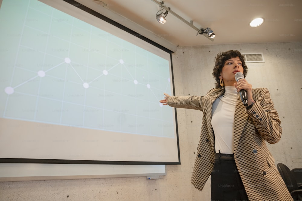 a woman standing in front of a projection screen