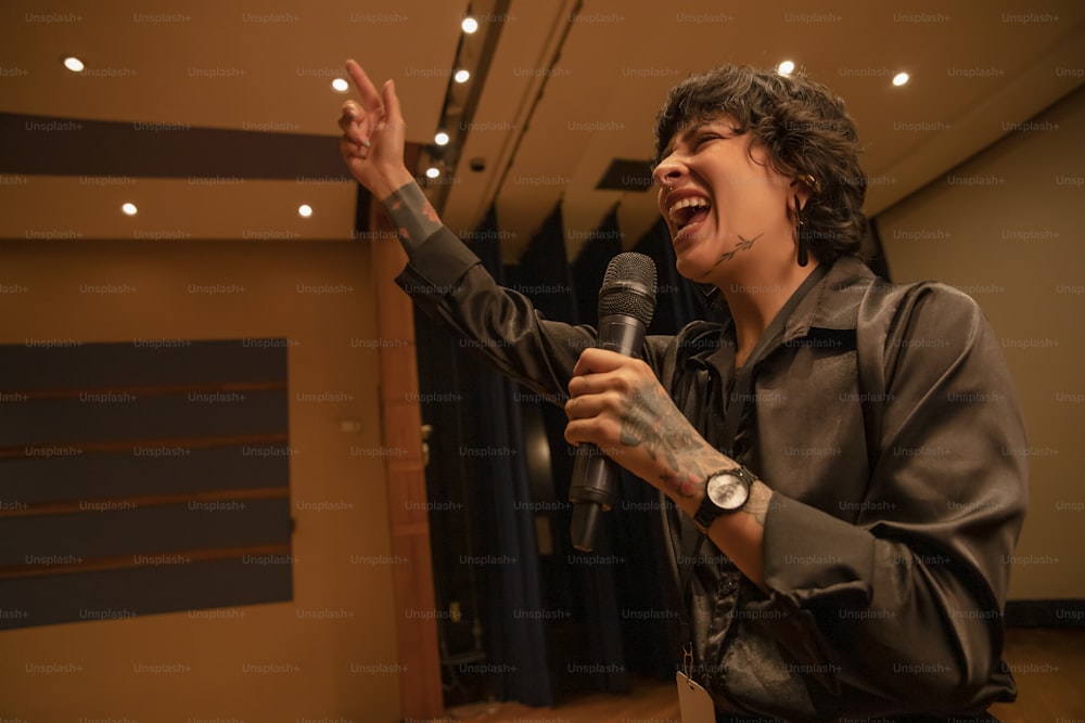 a woman singing into a microphone in a room