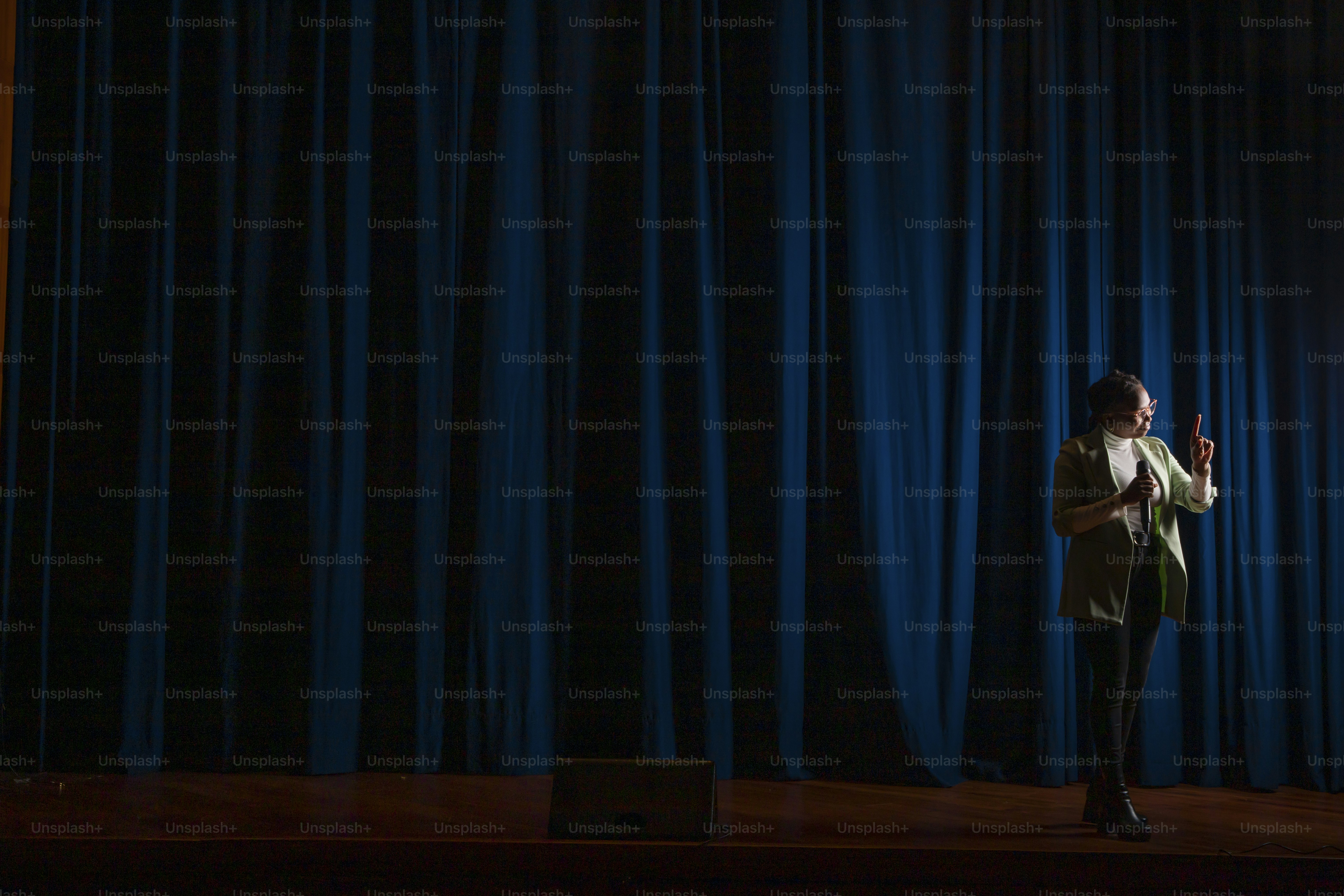 a woman standing in front of a blue curtain