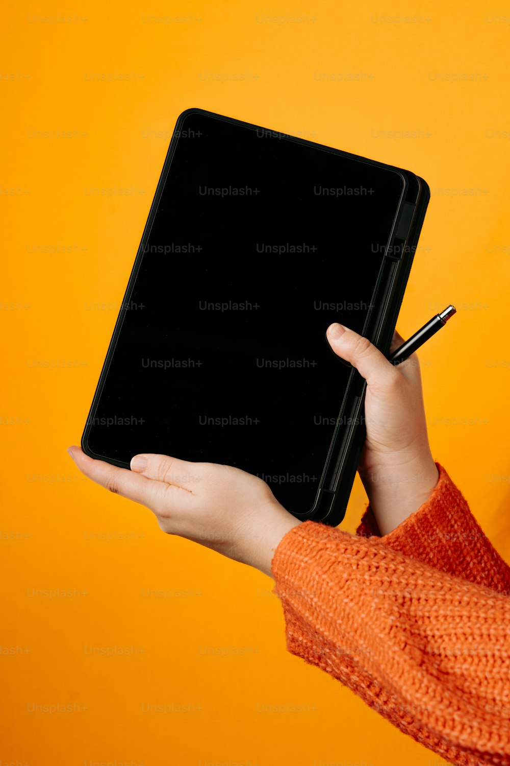 a person holding a tablet with a pen in their hand