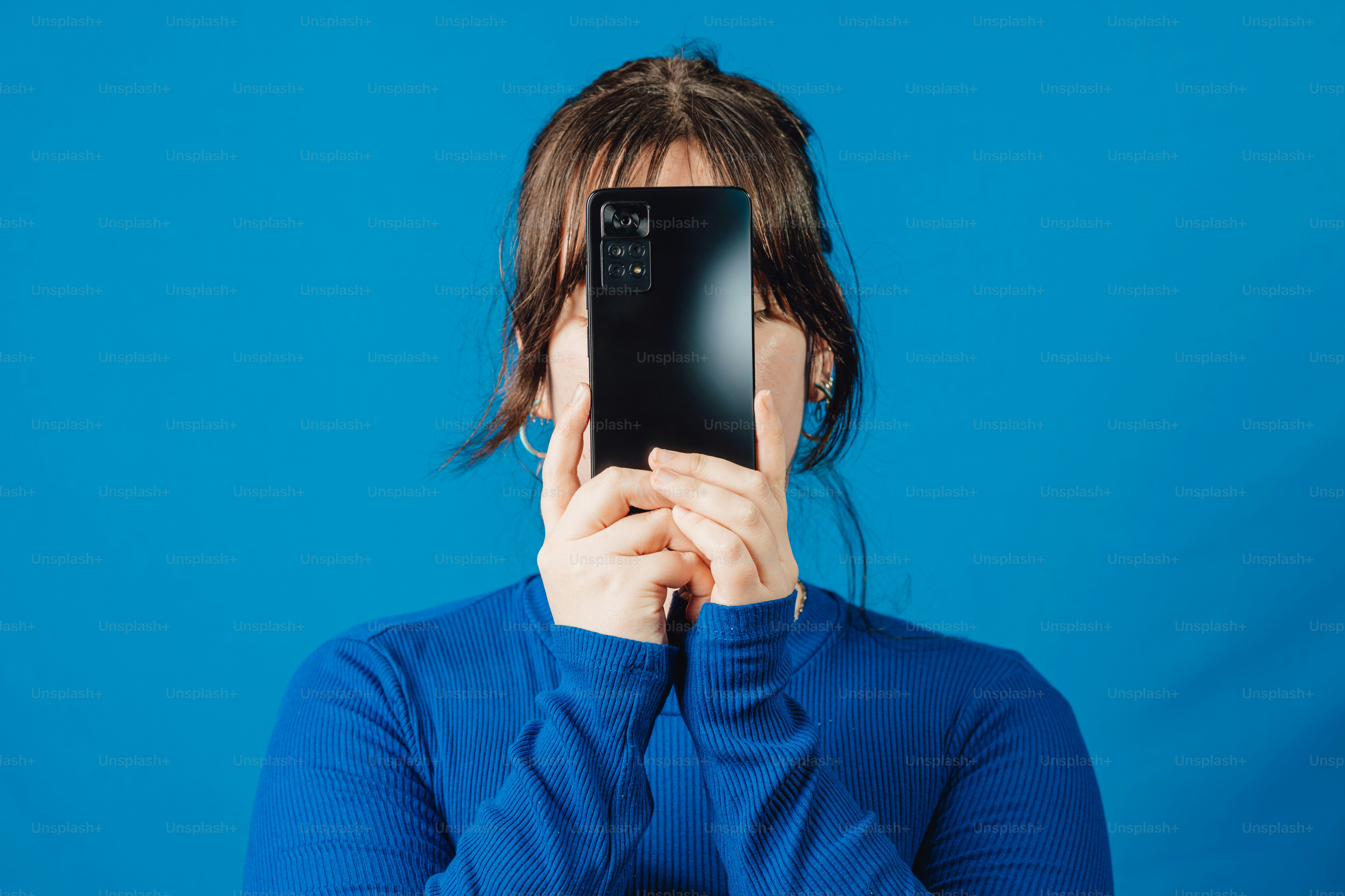 Eine Frau, die ein Selfie mit ihrem Handy macht Foto Bild zum Thema Mobiltelefon auf Unsplash