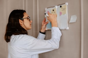 Una donna in camicia bianca sta lavorando su un interruttore della luce