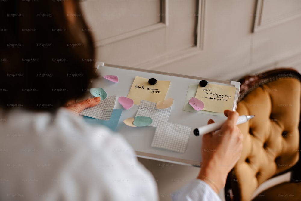 a woman holding a clipboard with sticky notes on it
