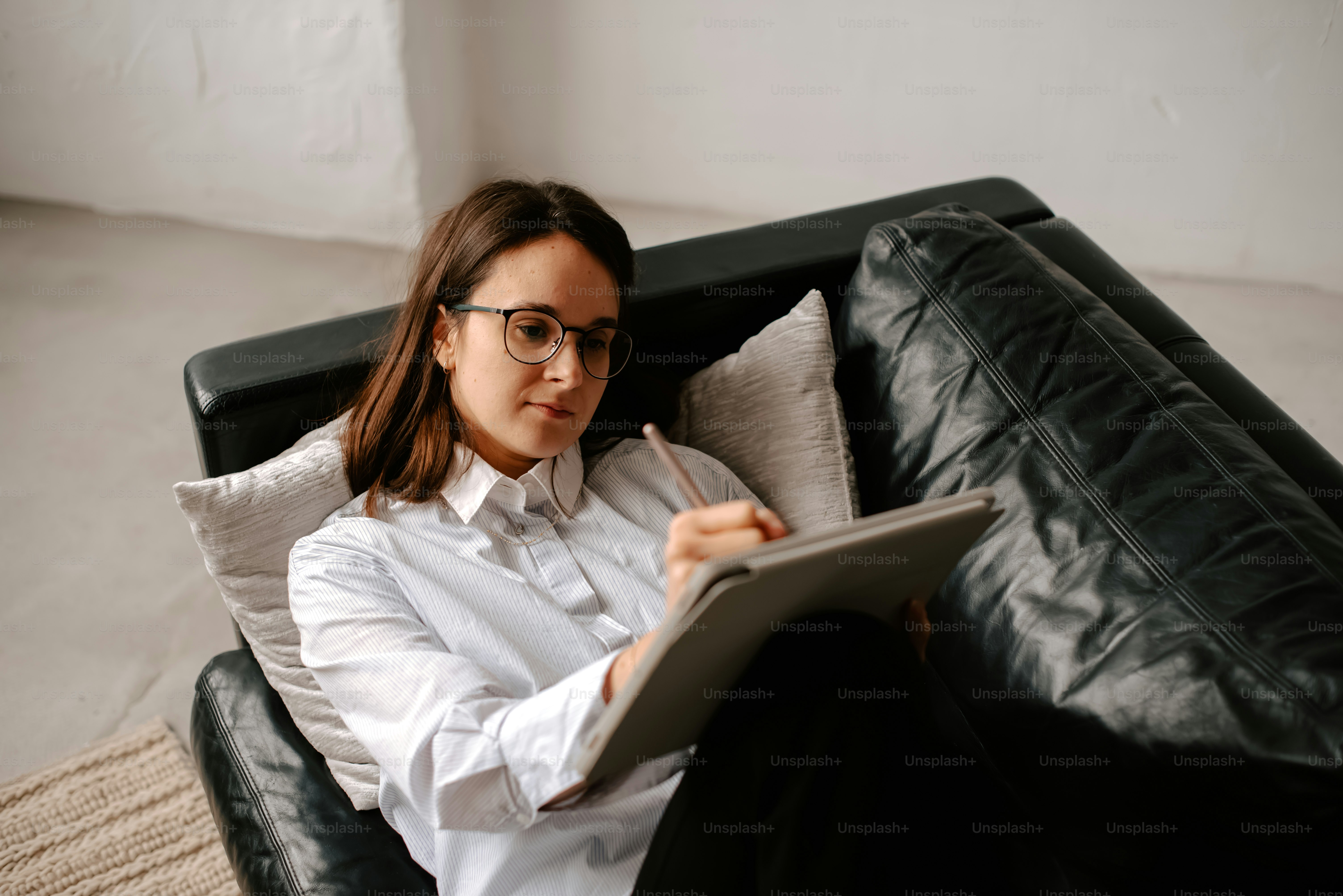 a woman sitting on a couch holding a tablet