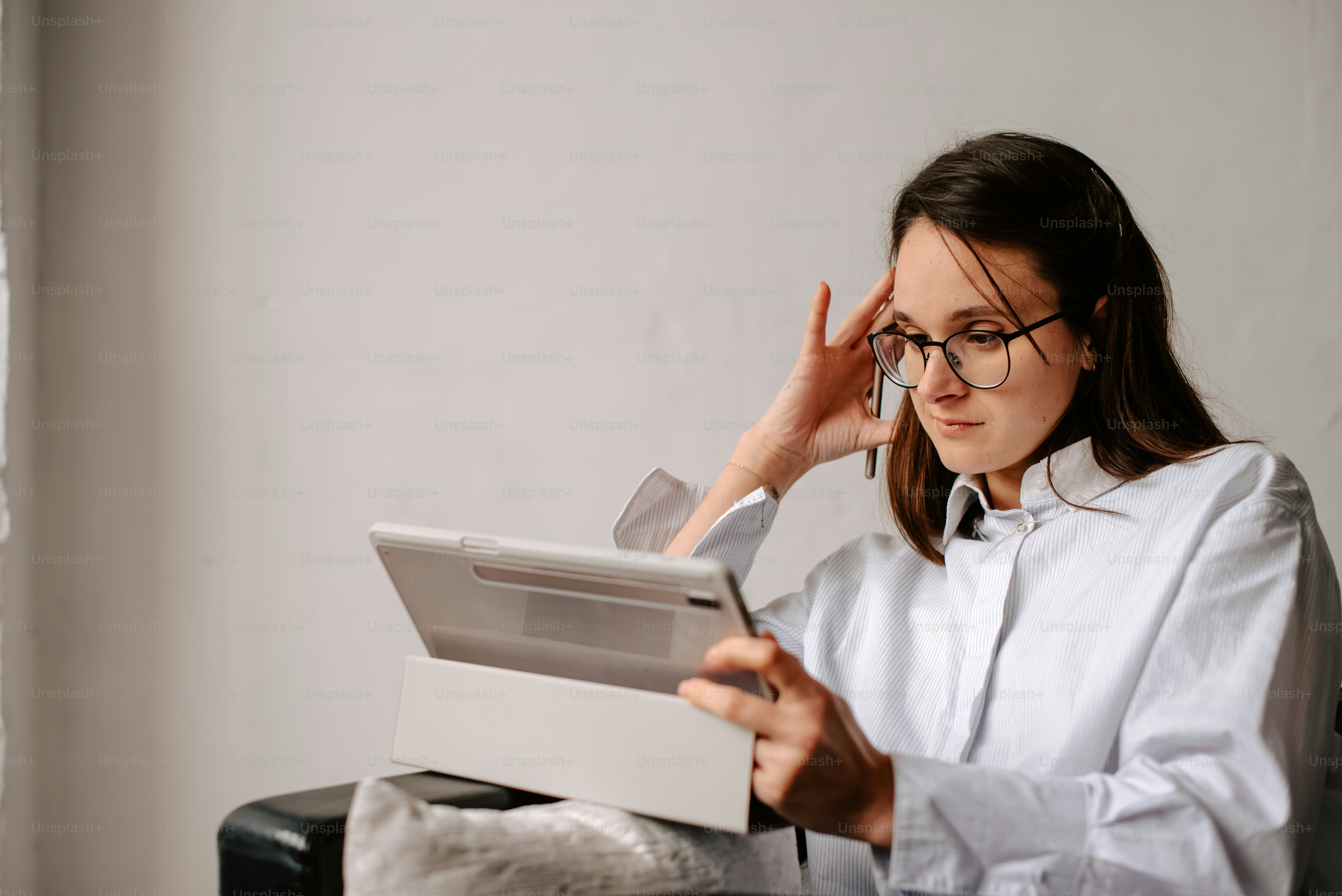 a woman sitting at a desk with a tablet