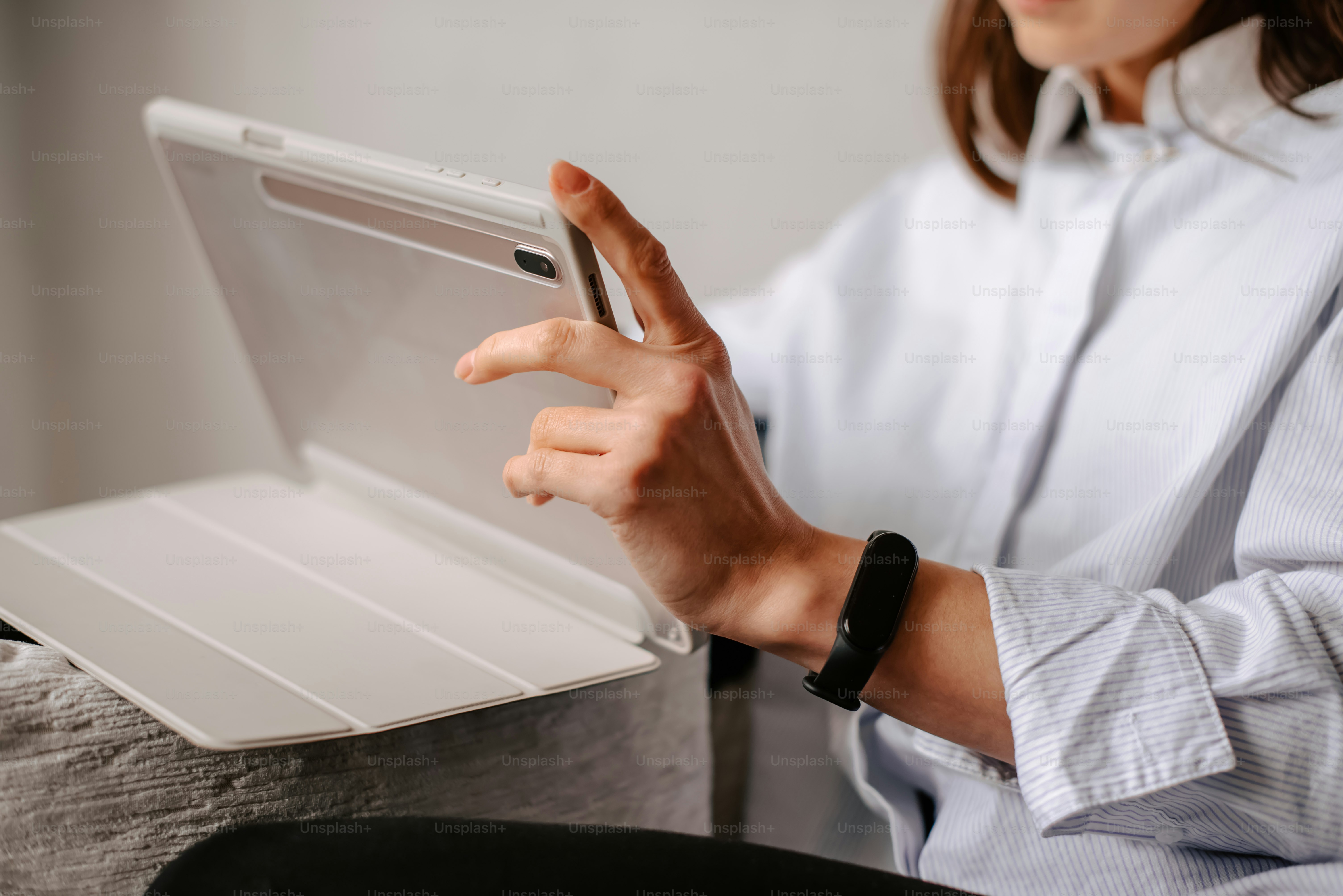 uma mulher sentada em um sofá segurando um tablet